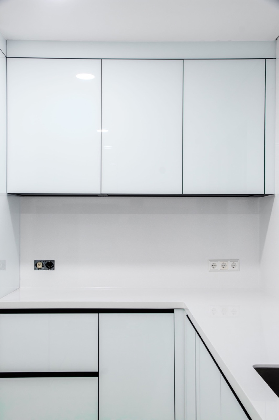 White acrylic kitchen with a continuous counter and backsplash